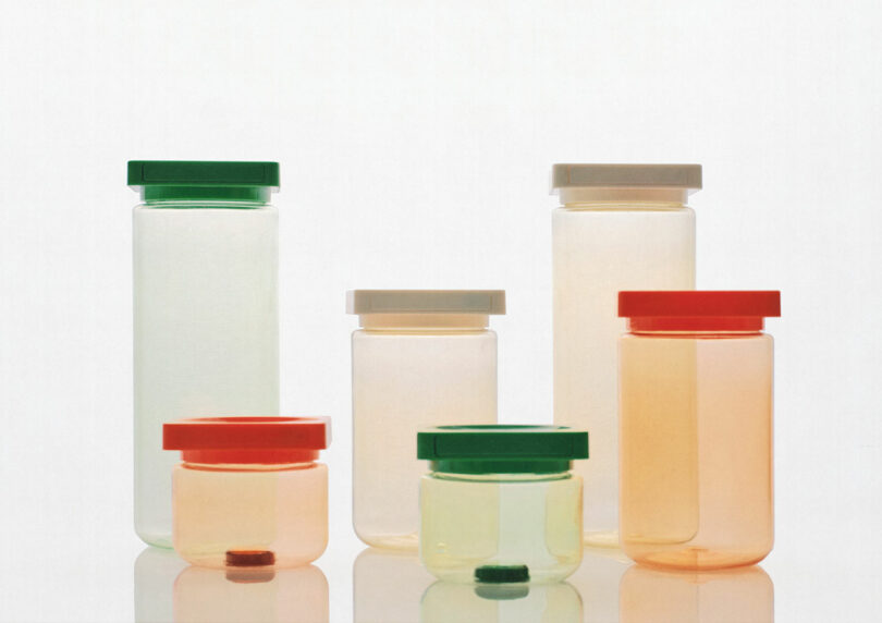 A grouping of six translucent plastic containers with colored lids, varying in size and shape, are displayed against a plain white background.