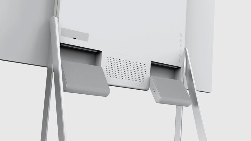 Close-up of the lower section of a modern, minimalist LG FLOW concept television design revealing its pair of detachable wireless surround speakers.