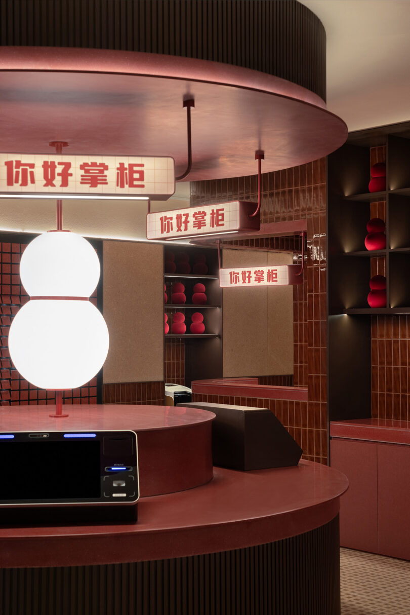 A modern, red-themed room in the NI HAO hotel with round light fixtures and illuminated Chinese signs. The space features contemporary furnishings and decorative elements.