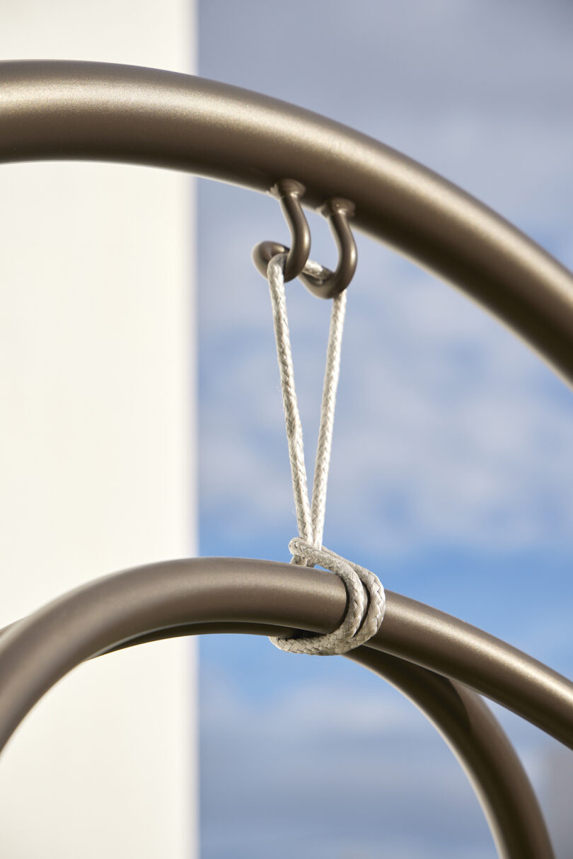 Close-up of a hooked metal rod tied with a white rope