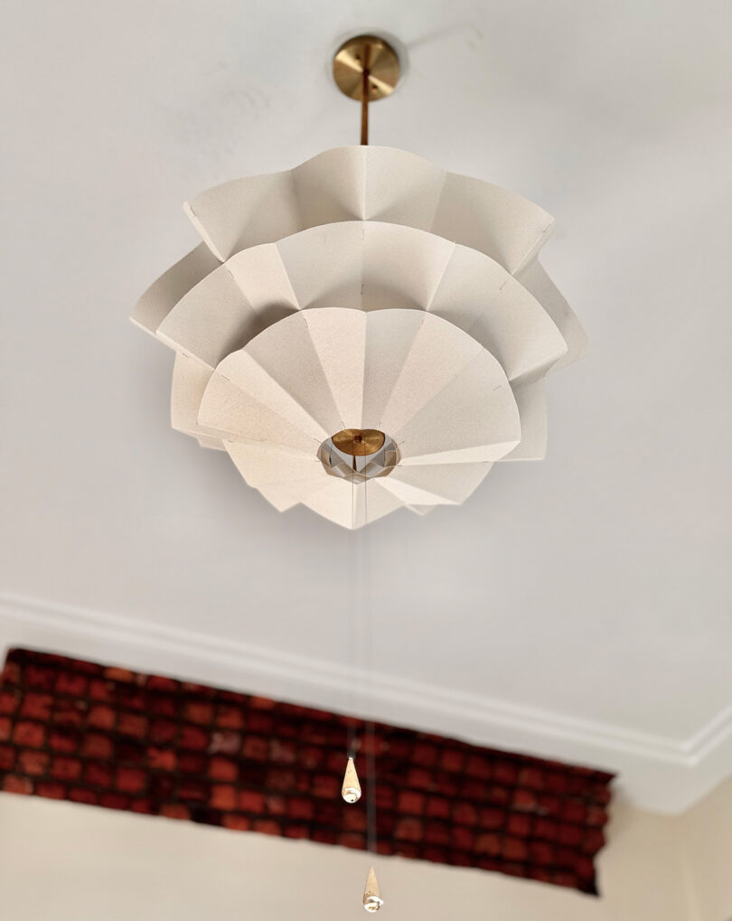 A modern white ceiling light fixture with a geometric design hangs from the ceiling.