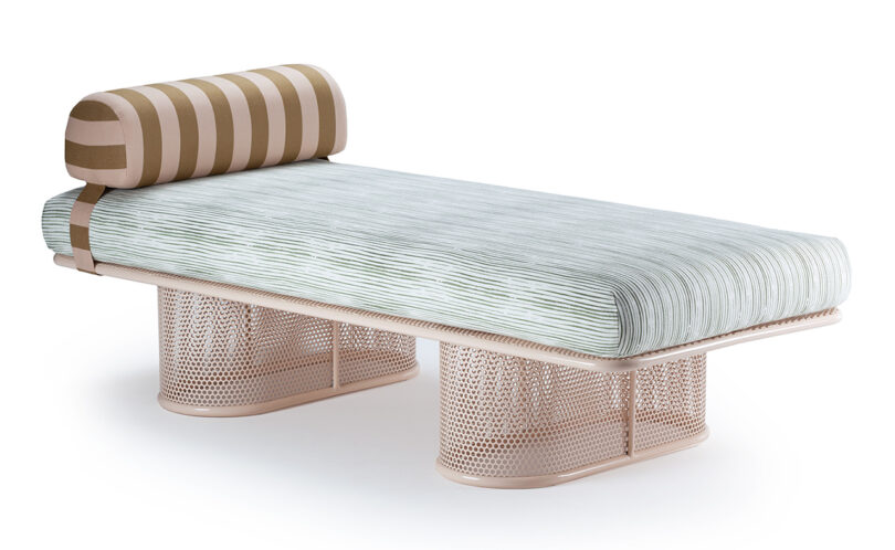 A modern chaise lounge with a striped cylindrical cushion, horizontal striped mattress, and a perforated metal base.