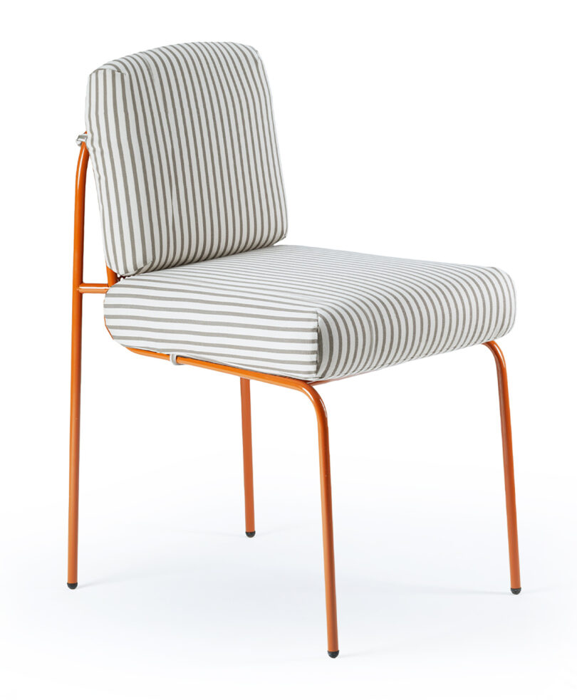 A chair with an orange metal frame and cushioned seat and backrest, upholstered in a white and gray vertical striped fabric.