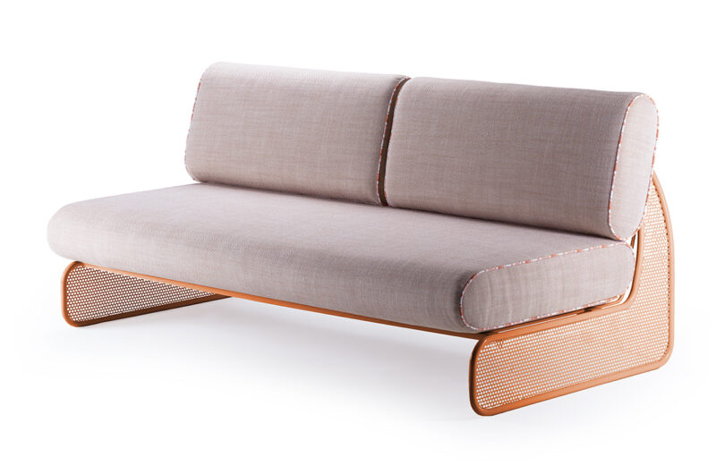 A modern couch seat with a curved, perforated metal frame and beige cushioned seat and backrest.