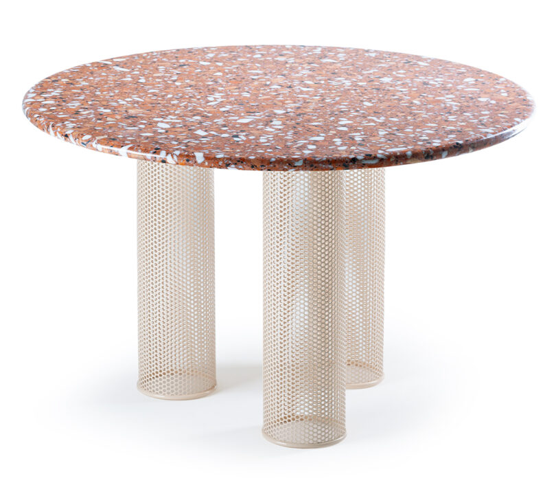 A round table with a terrazzo top and three cylindrical mesh legs.