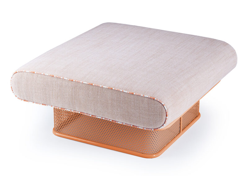 A beige pouf with a rounded rectangular top and a perforated orange metal base shown against a white background.