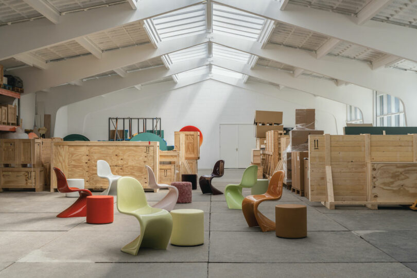 White warehouse with an array of colorful plastic chairs and several ottomans