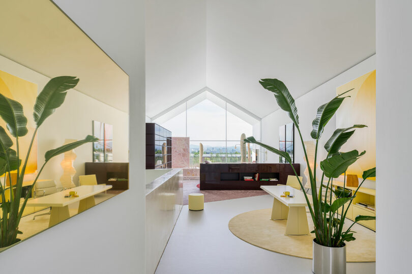 Interior shot of long pitched roof space with yellow mirror on left and living space to the right and further off.