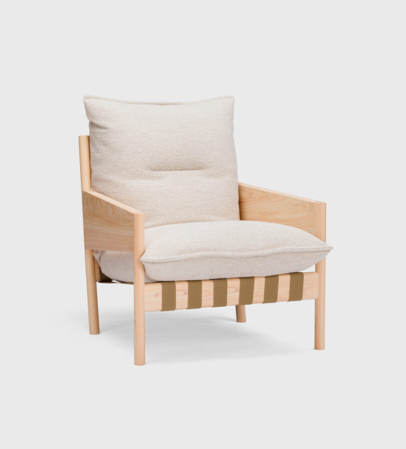 A wooden armchair with light beige cushions, featuring a minimalist design