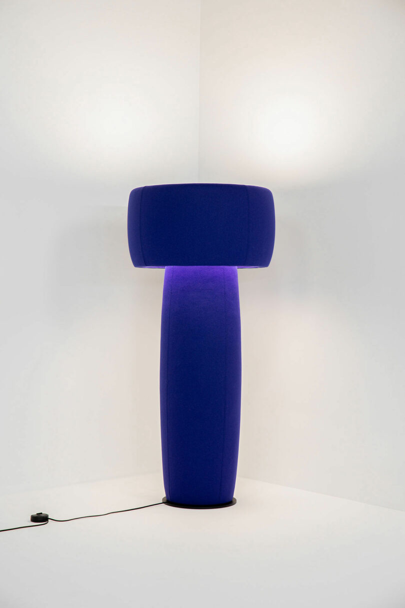 purple floor lamp in the corner of a white room