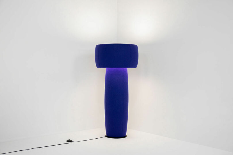 purple floor lamp in the corner of a white room