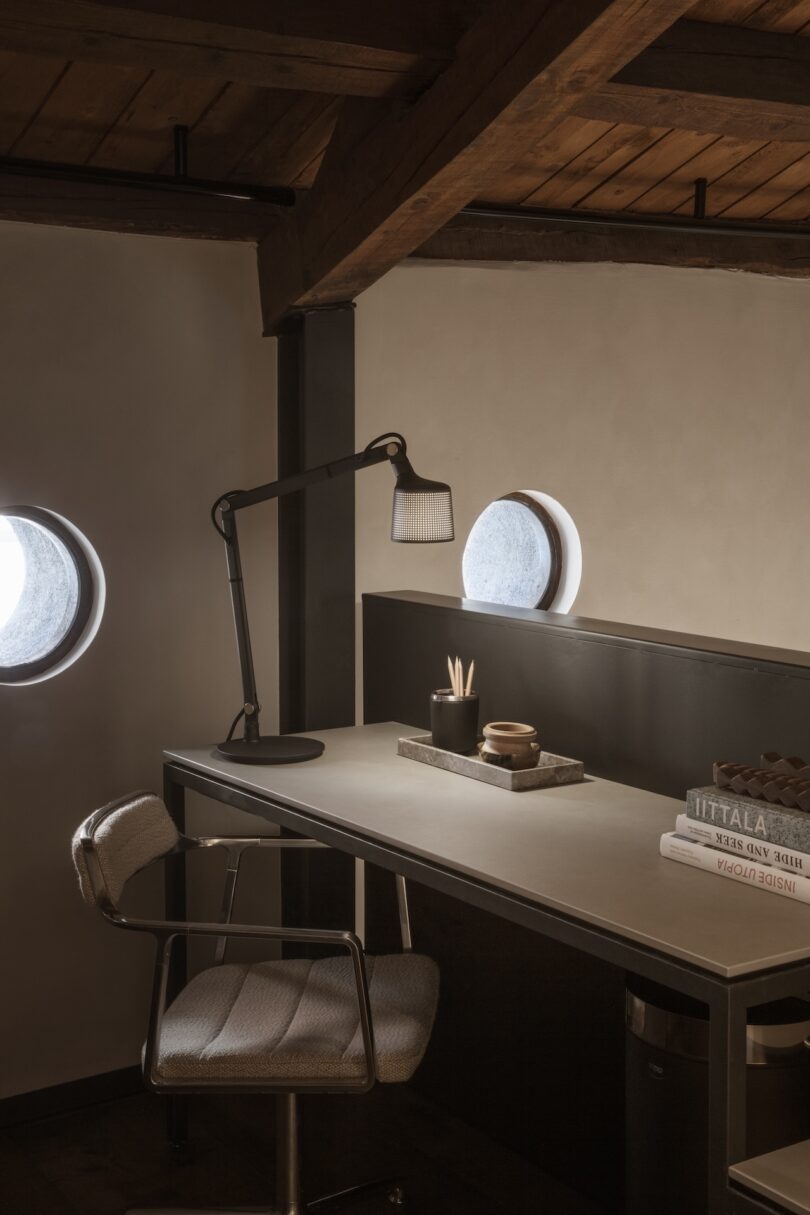 Office area with a sleek black desk lamp and circular windows at Casa Vipp Andorra