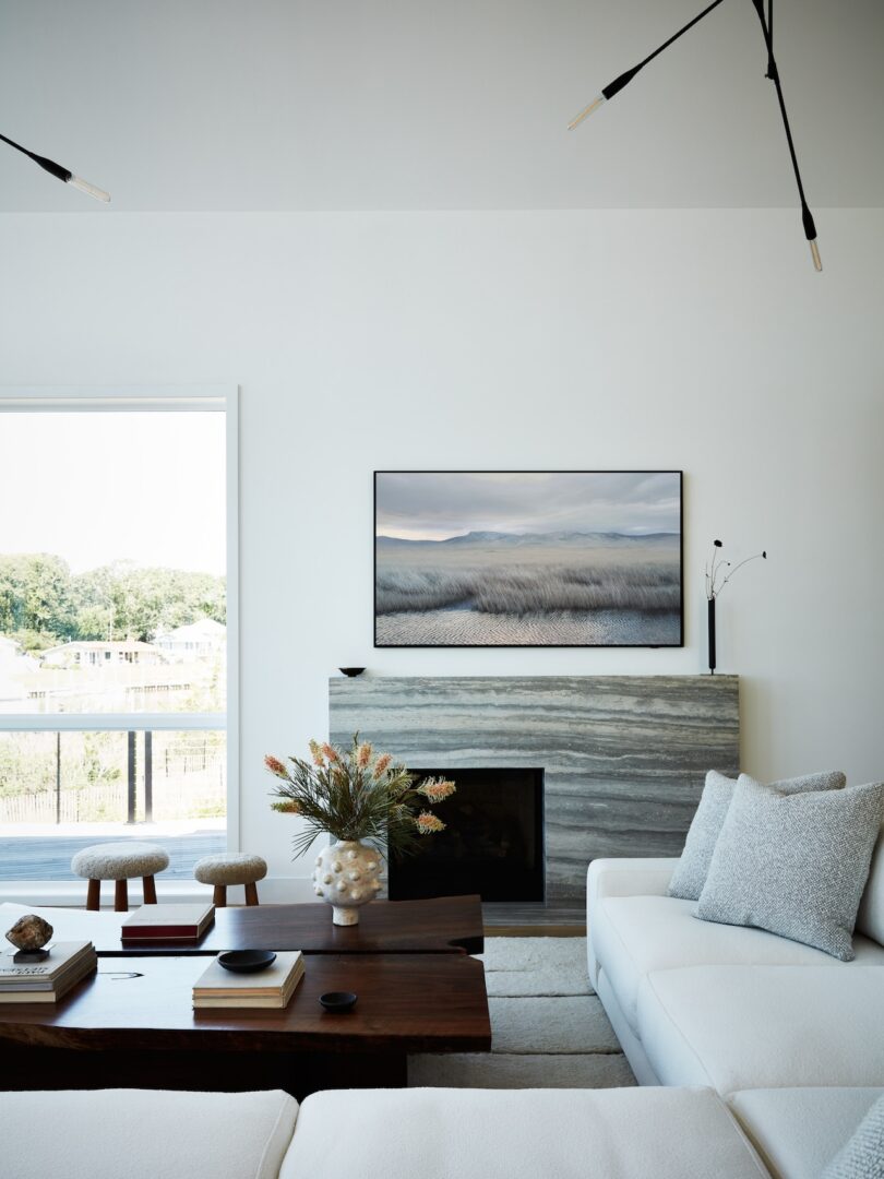 Living room with modern furniture and a large landscape photograph above the fireplace