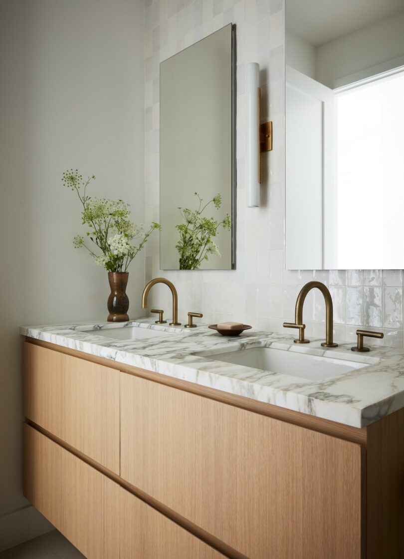 Bright bathroom with marble countertop and brass fixtures