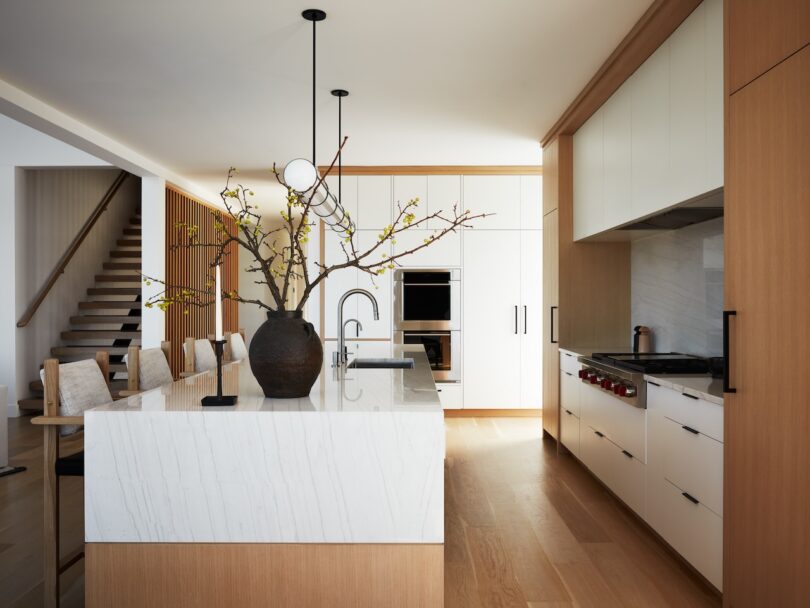 Modern kitchen with large island, white countertops, and wooden cabinetry