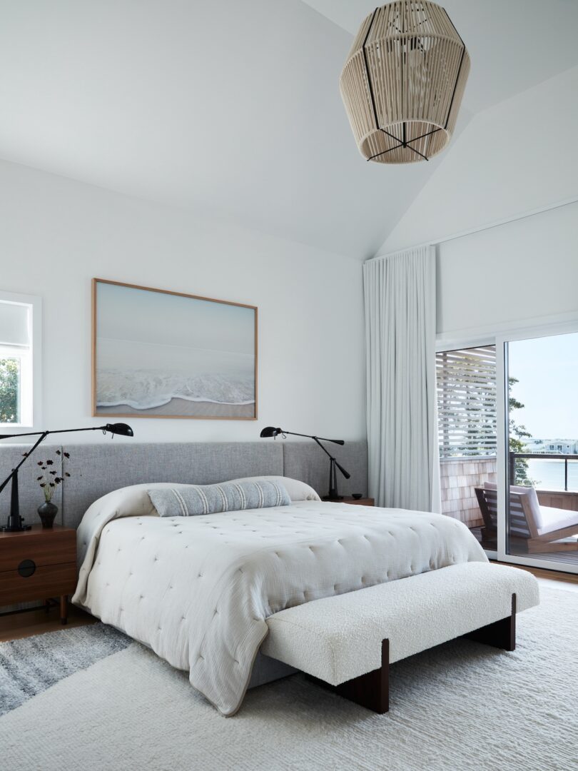 Minimalist bedroom with white bedding and a large window
