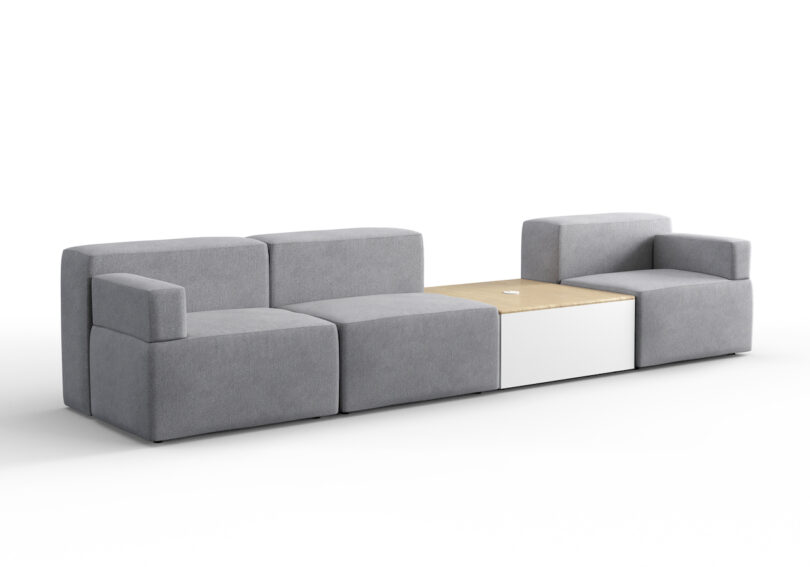 A modular gray sofa with a built-in light wood and white center console table. The configuration includes three seats on the left and an armchair on the right