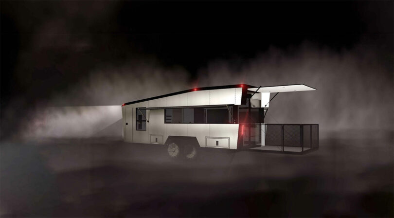 A modern, angular CyberTrailer with illuminated red and white lights sits in a foggy, dark environment. One side of the trailer is extended open.