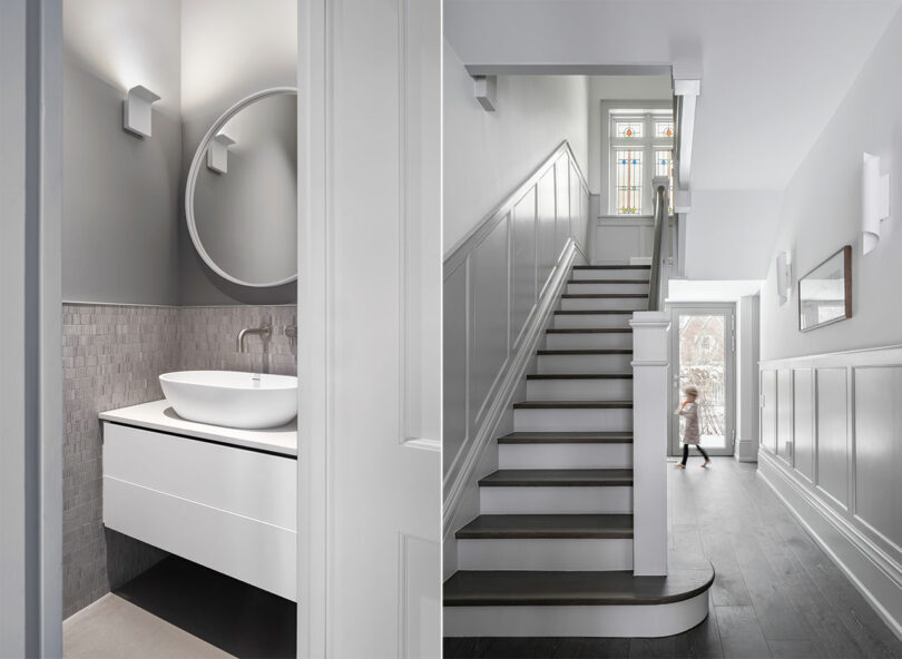 A modern bathroom with a round mirror and sink reflects sleek architecture adjacent to another hallway with a staircase and a walking child.