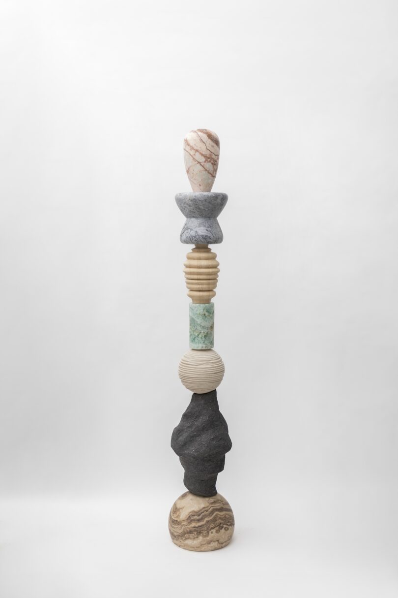 Full view of a sculptural totem from Sten Studio's "Cosmic Relics" collection, featuring a combination of stones in different shapes, colors, and textures
