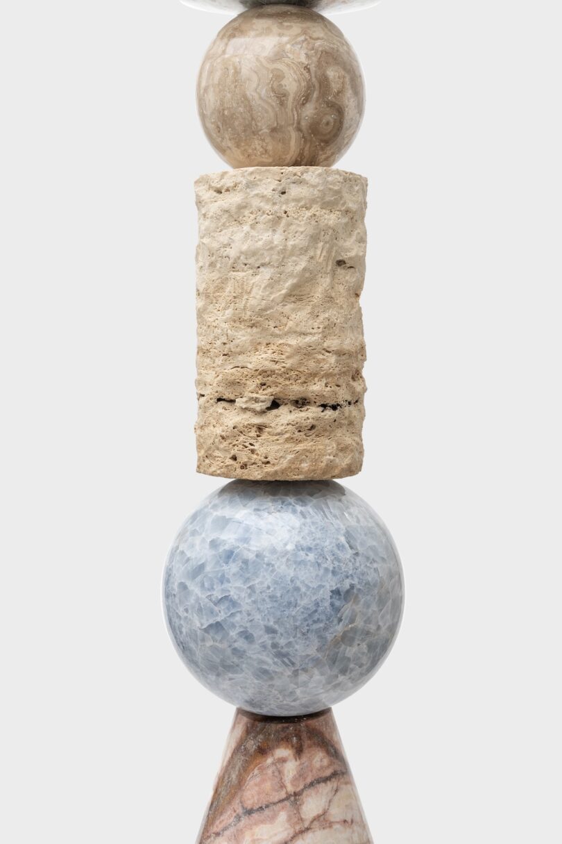 Detail of a stacked sculpture from Sten Studio's "Cosmic Relics" collection, highlighting the combination of travertine marble, blue calcite, and other stones in a vertical arrangement