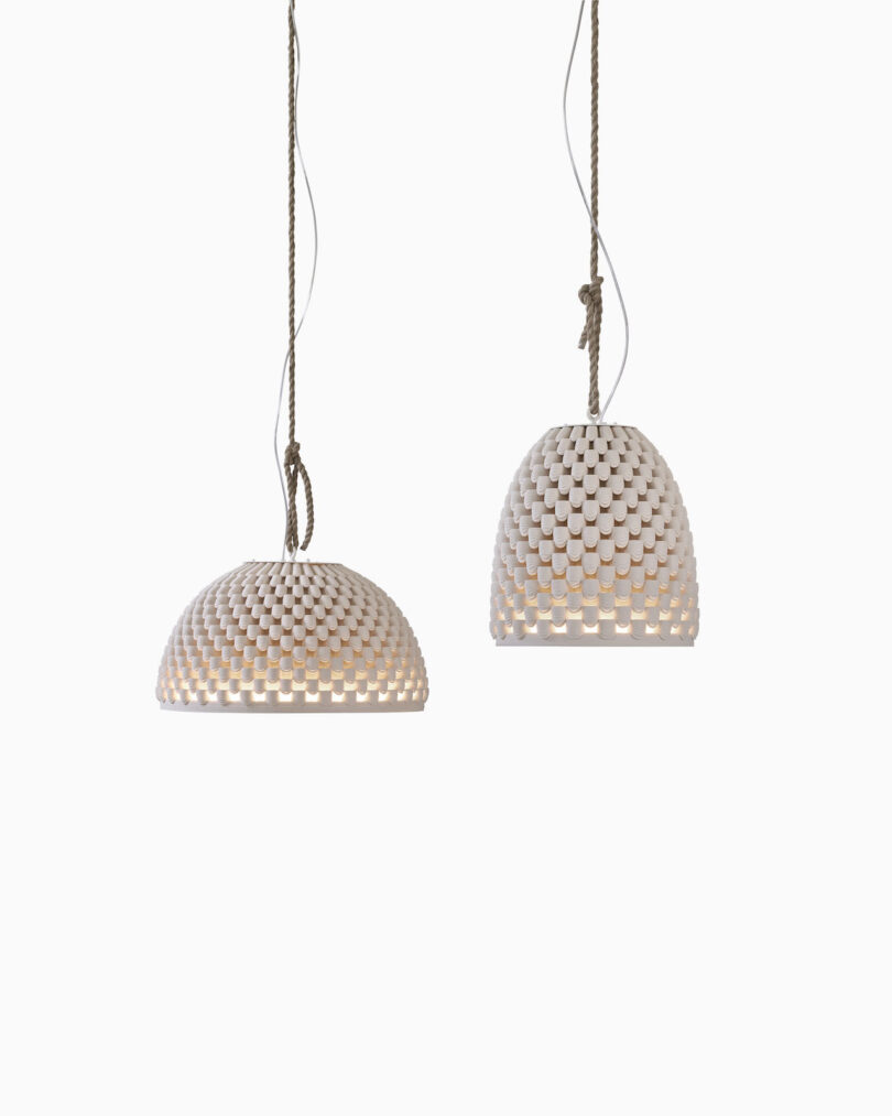 Two pendant lights hang from the ceiling on brown ropes against a plain white background.