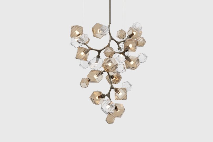 A modern chandelier with multiple hexagonal glass shades in clear and amber tones arranged in an organic, branching structure