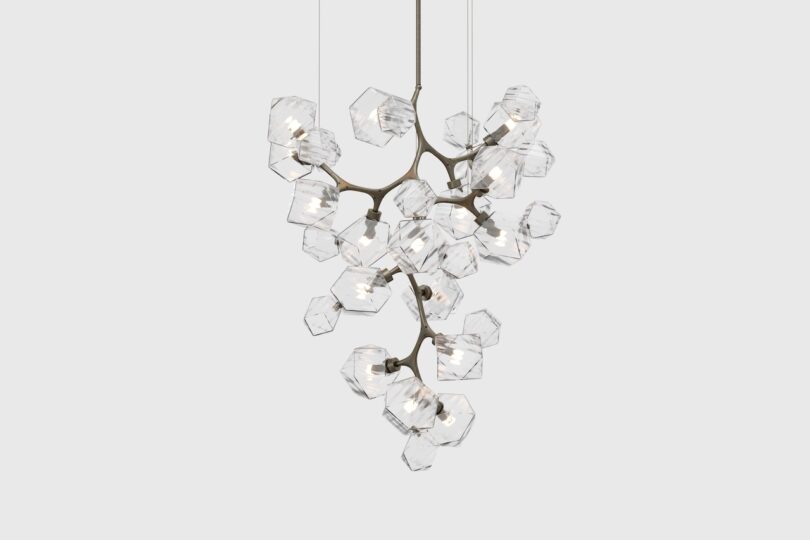 A modern chandelier with a branching design and multiple hexagonal glass shades, each containing a light bulb, suspended from a ceiling