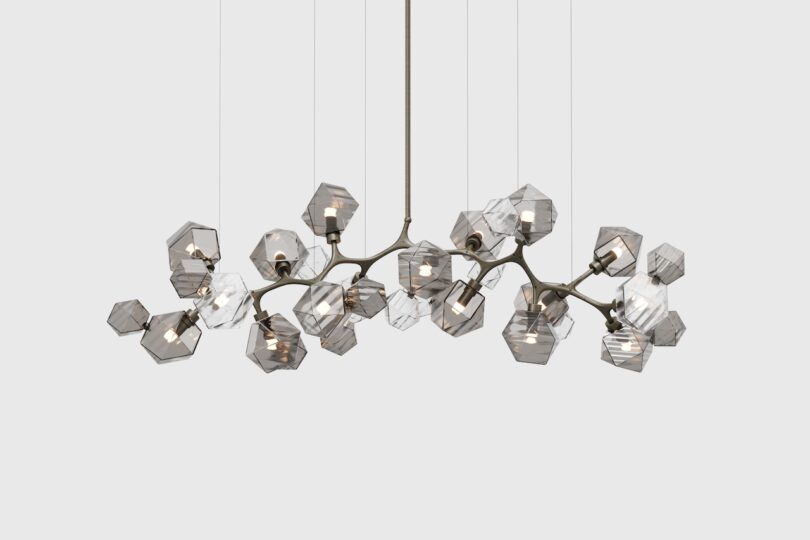 Modern chandelier with multiple geometric glass lampshades and a metallic frame, suspended from the ceiling