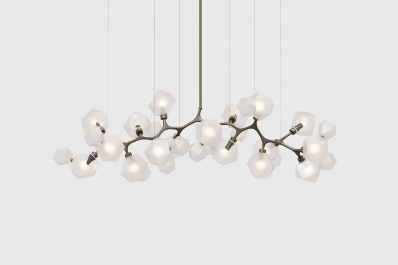 Modern chandelier with multiple geometric-shaped lights hanging from a central fixture against a plain background.