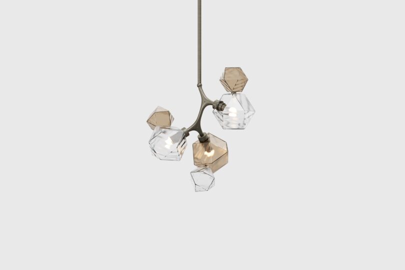 Modern hanging light fixture with multiple geometric, transparent shades, some clear and some tinted, attached to a central stem