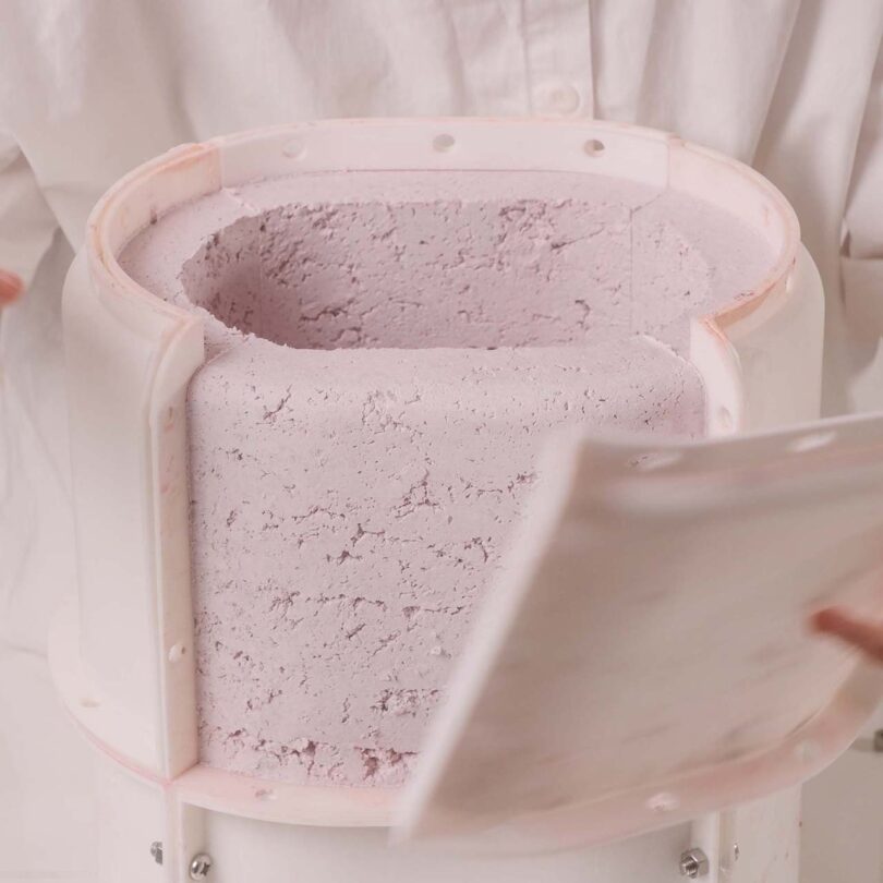 Emeline Ong making the Pastille Collection, a mold filled with a light pink, paper composite.