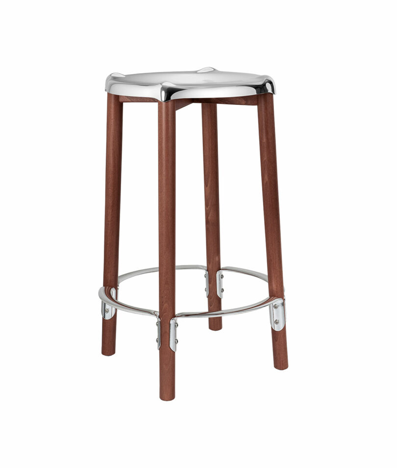 The Poele High Stool with a metal seat and footrest on a white background.