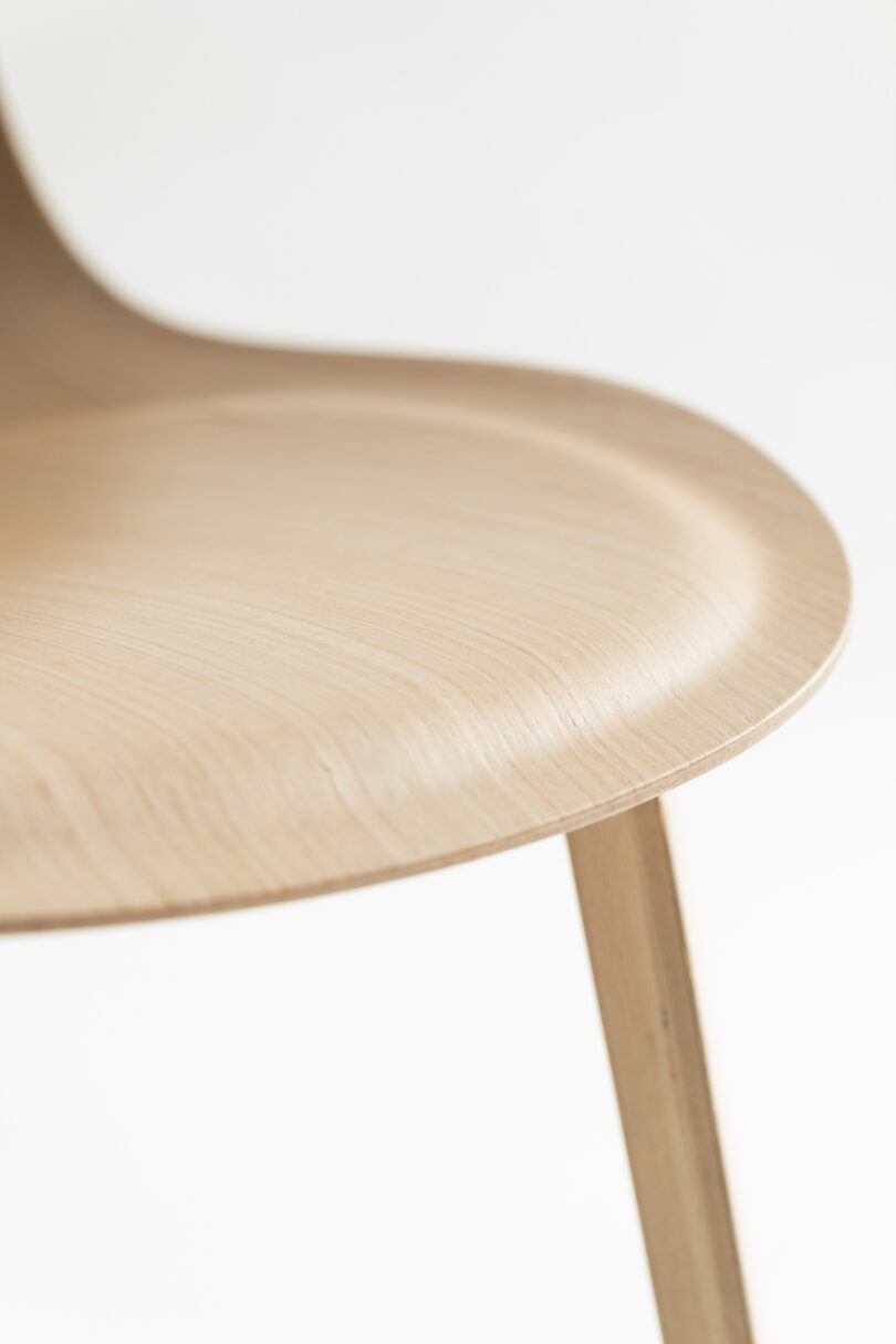 upclose details of A light wood, curved chair 