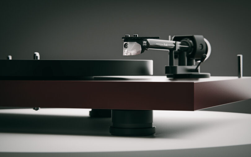 Close-up of a turntable, showing the tonearm and stylus ready to play a vinyl record, with a sleek and minimalist design.