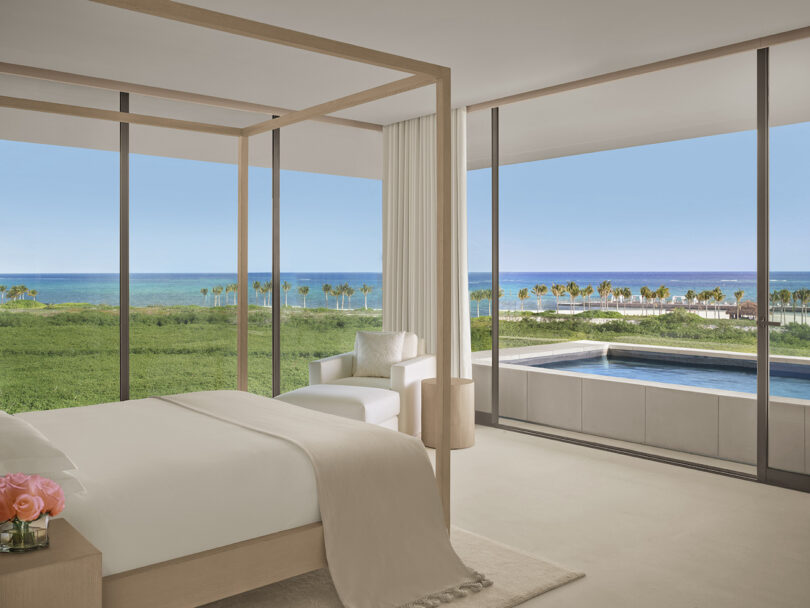 A guest room at The Riviera Maya EDITION with floor-to-ceiling glass doors opening to an oceanfront terrace