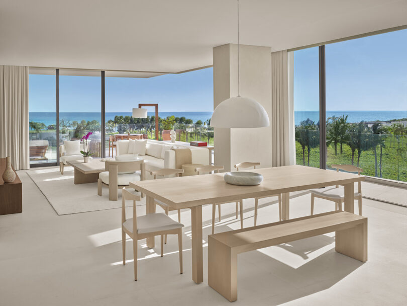 An expansive living and dining area in the Sky Rooftop Villa at The Riviera Maya EDITION, offering panoramic ocean views through floor-to-ceiling windows