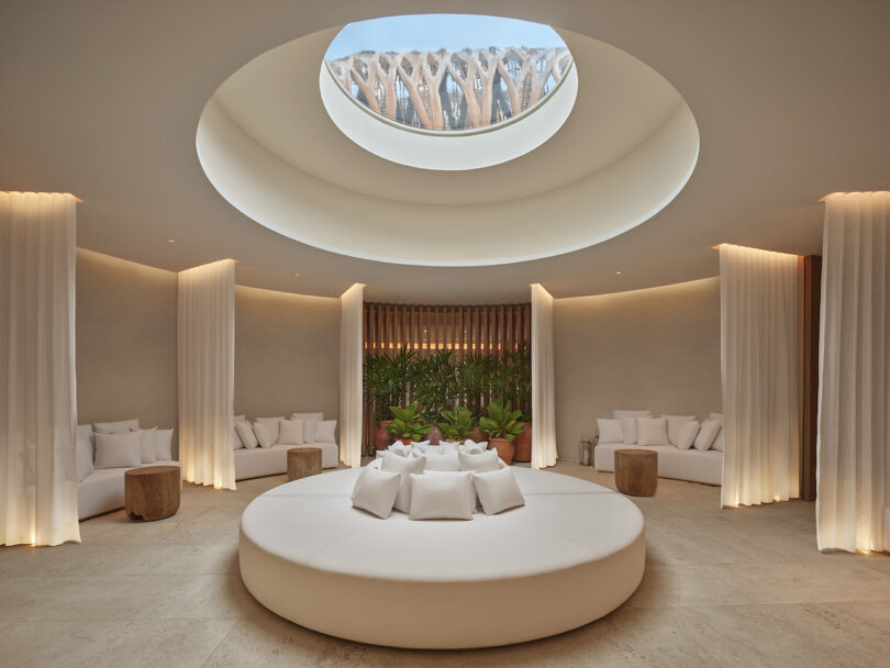 A circular lounge area beneath a skylight at The Riviera Maya EDITION spa, inspired by a cenote