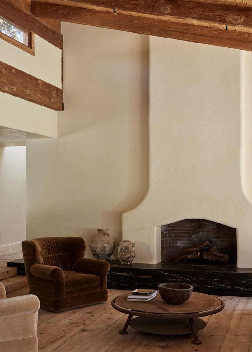 A living room with a tall plastered fireplace as the focal point