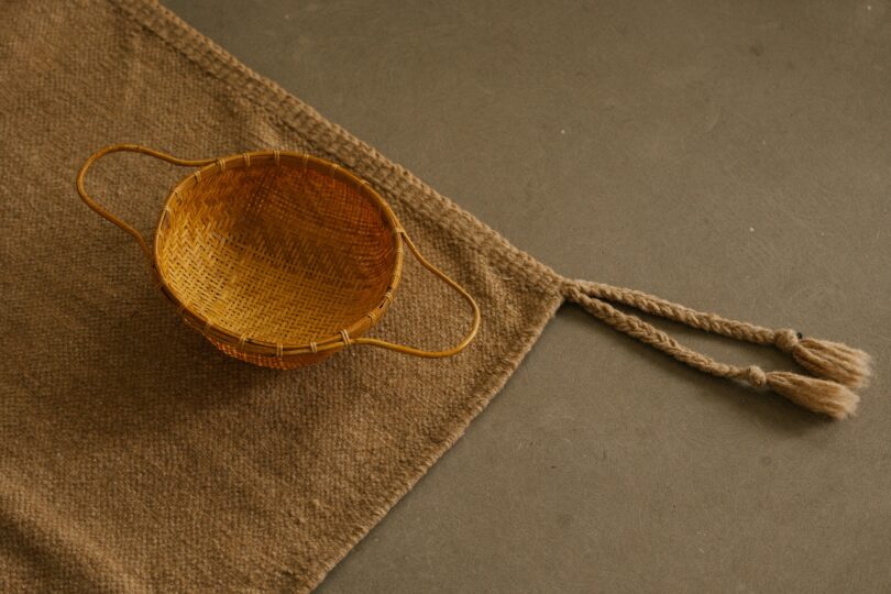 A woven basket resting on a natural wool Beni rug