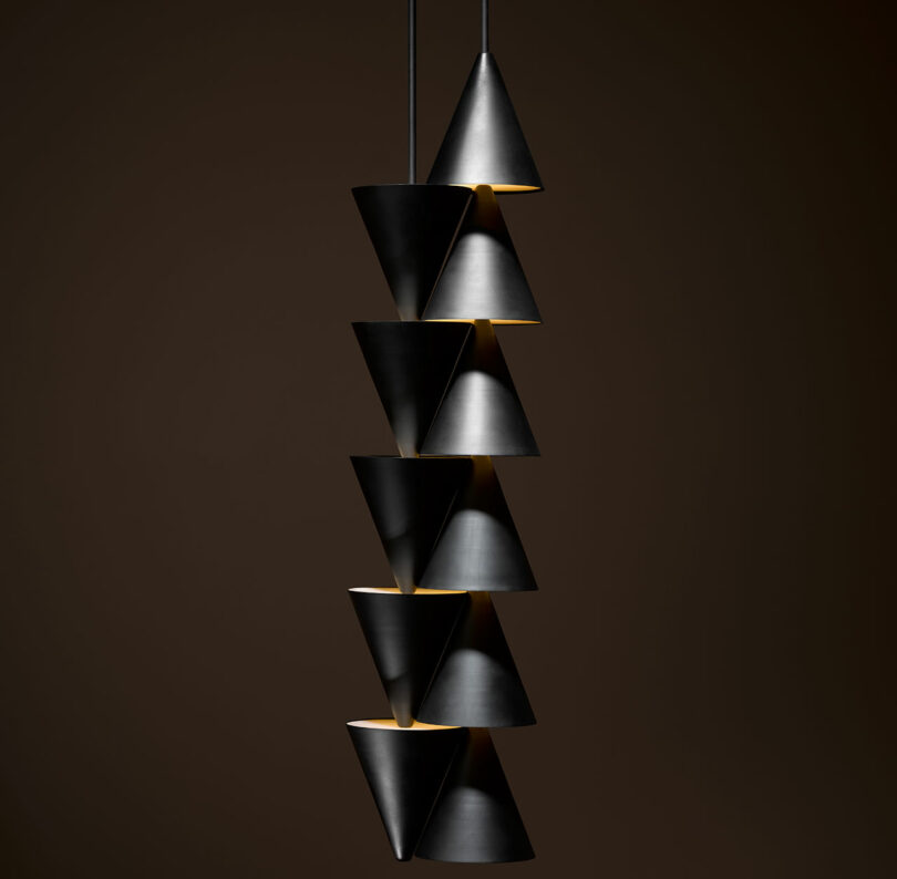 A Legato Light modern pendant light fixture composed of eight black conical shades stacked in alternating directions against a dark background.