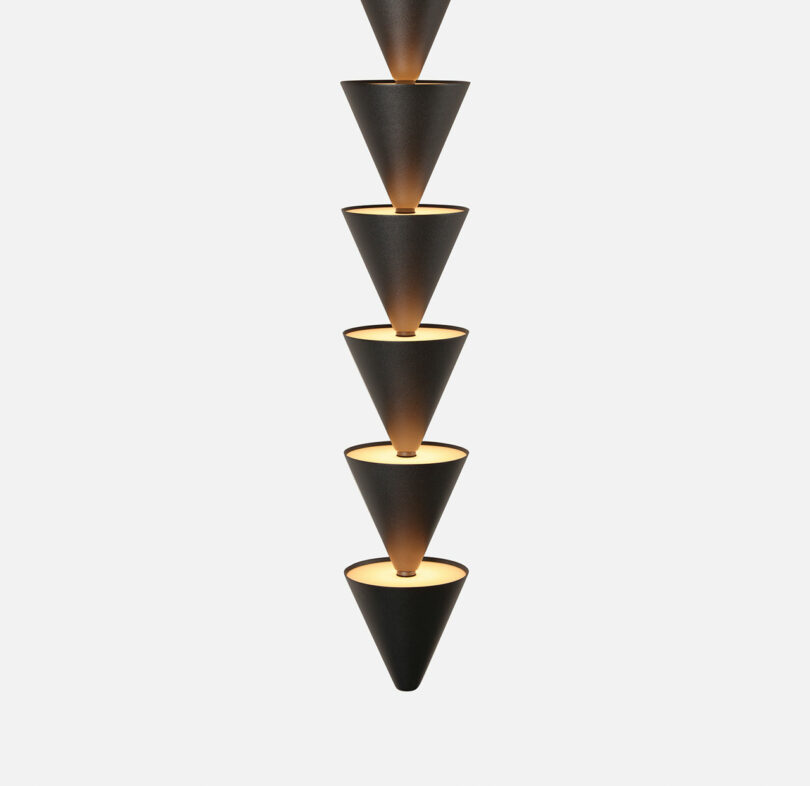 A close up of the Legato Light - a group of black and gold cone shaped lights.