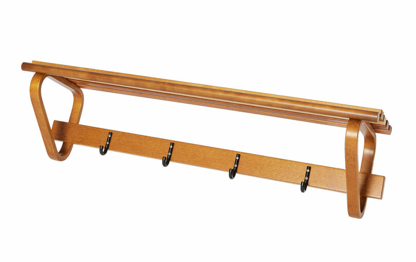 Coat Rack 109 by Alvar Aalto with a shelf on top and five metal hooks below, designed for mounting on a wall.