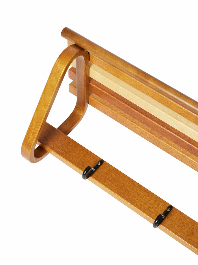 Coat Rack 109 by Alvar Aalto with a minimalist design, featuring a curved frame and multiple horizontal slats for holding towels.