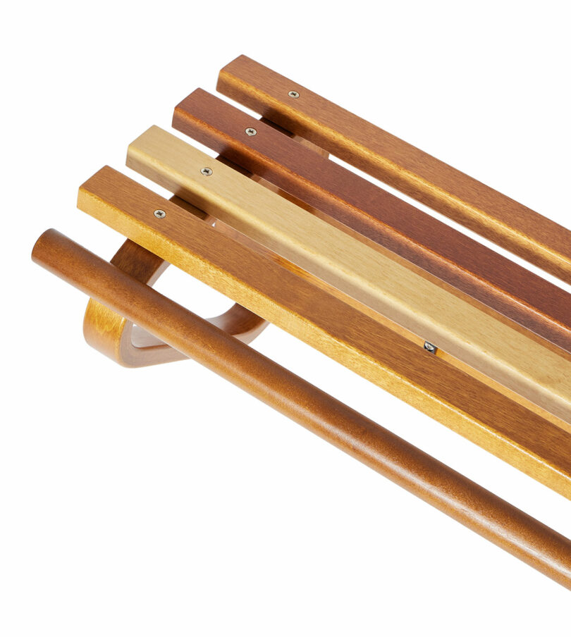 Close up of Coat Rack 109 by Alvar Aalto with a classic design, featuring natural wood slats and a curved handlebar.