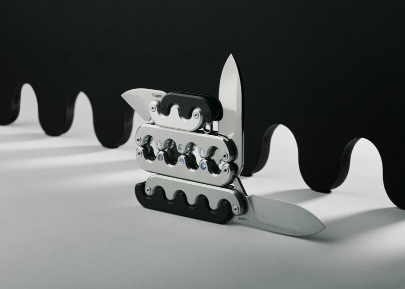 A collection of folding pocket knives with various blades and tools against a black and white background.