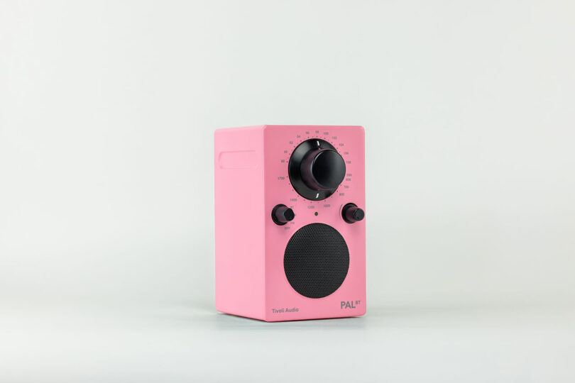 A pink portable radio with a large black tuning dial, smaller volume and tone knobs, and a round speaker grill on the front. "Tivoli Audio" and "PAL BT" are elegantly printed on this stylish device.