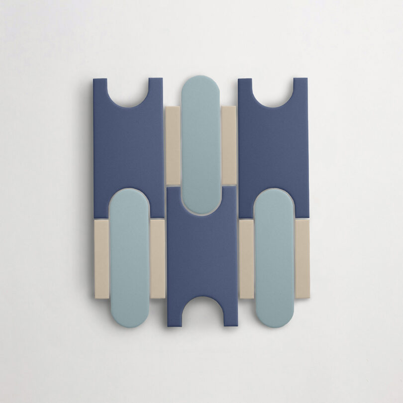 A Tivoli Tech tile featuring a symmetrical arrangement of blue, light blue, and beige rectangular and rounded shapes on a white background.