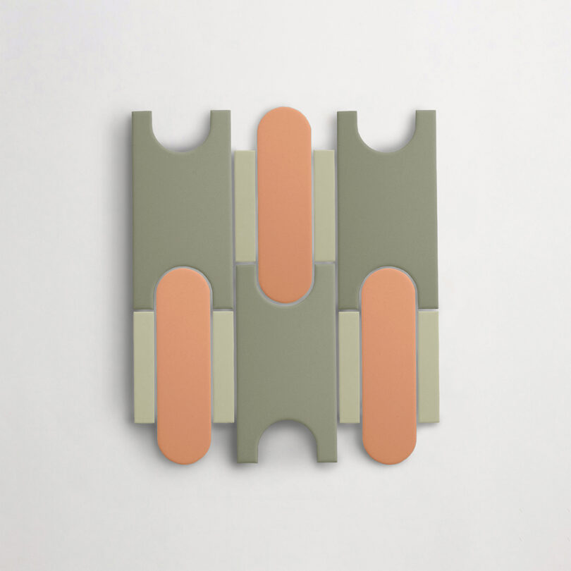 A Tivoli Tech tile by Cristina Celestino with interlocking shapes in muted green and peach tones on a white background.