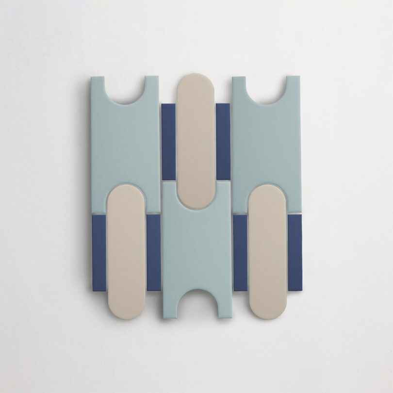 A tile featuring vertically and horizontally aligned blue, beige, and navy rectangular shapes with rounded and notched ends against a white background.